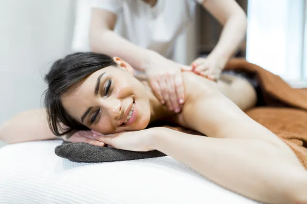 Mujer acostada en una mesa de masaje y relajante — Foto de Stock