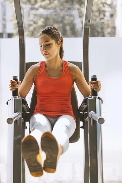 Kvinna som arbetar på abs i ett gym — Stockfoto