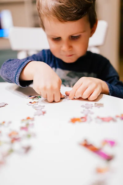 Child solving jigsaw puzzle — Stock Photo, Image