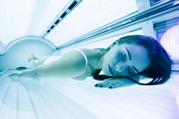 Mooie vrouw liggend in solarium — Stockfoto