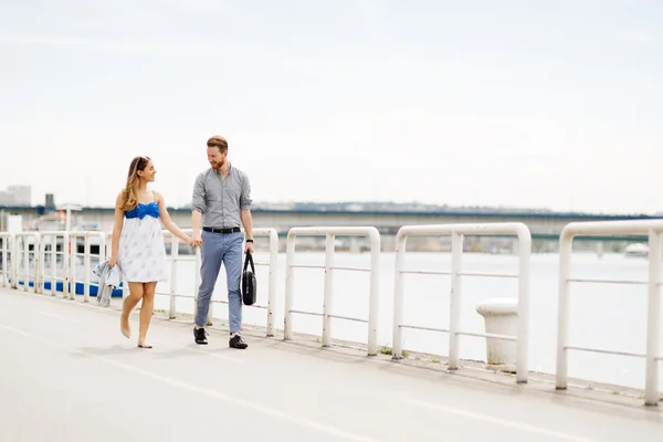 Casal feliz andando na beira do rio — Fotografia de Stock