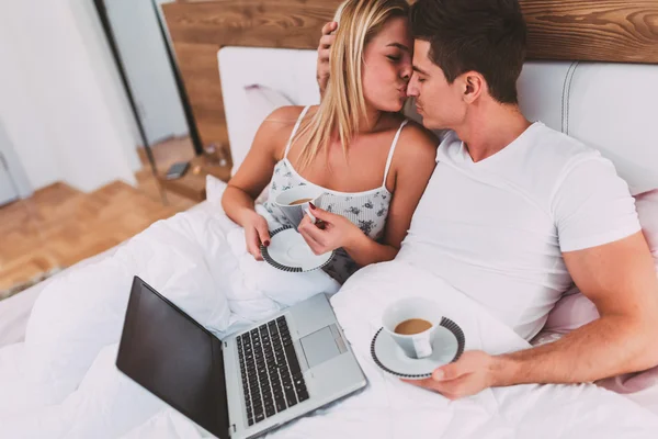 Пара розслабляється в ліжку з кавою — стокове фото