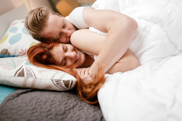 Hermosa pareja sonriendo en la cama — Foto de Stock