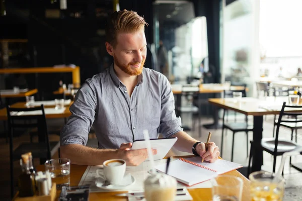 Бізнесмен робить нотатки в кафе — стокове фото