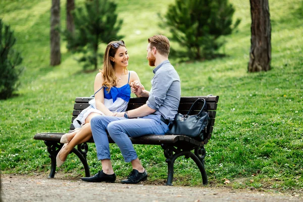 Namoro casal sentado no banco — Fotografia de Stock