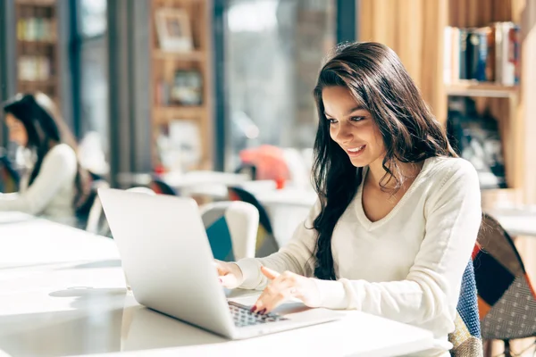 Piękna brunetka kobieta korzysta z laptopa — Zdjęcie stockowe