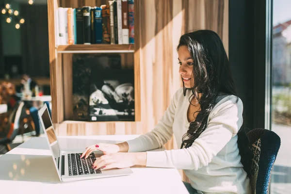 Bruneta femeie using laptop în cafenea — Fotografie, imagine de stoc