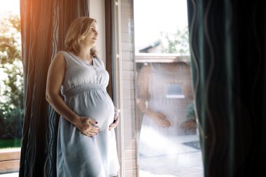 Karnını tutan hamile kadın.