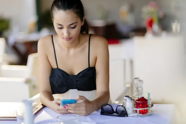 Hermosa mujer usando el teléfono en el restaurante — Foto de Stock