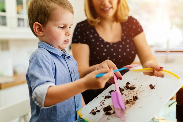 Criança inteligente ajudando a mãe na cozinha — Fotografia de Stock