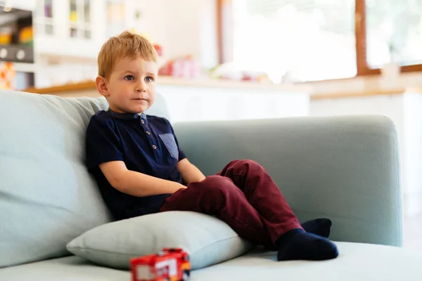 Ragazzo seduto sul divano del soggiorno — Foto Stock