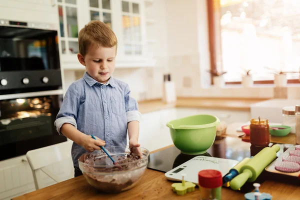 Милый ребенок учится быть шеф-поваром — стоковое фото