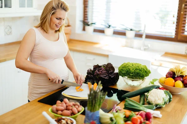 Красива вагітна жінка готує їжу — стокове фото