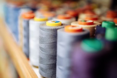 Colorful thread spools used in fabric industry clipart