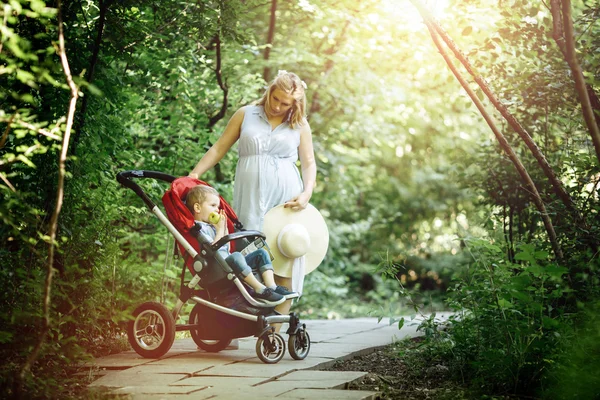 Donna che cammina con bambino nella foresta — Foto Stock