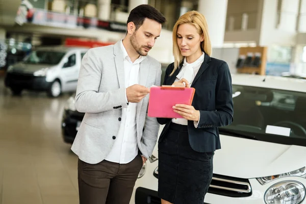 Cliente olhando para carros na concessionária — Fotografia de Stock