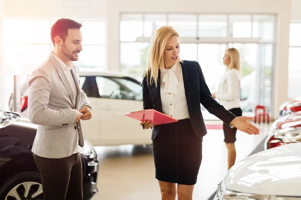 Salesperson showing vehicle to potential customer — Stock Photo, Image