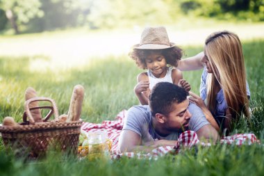 Family picnicking outdoors clipart