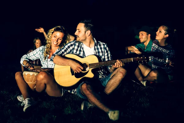 Arkadaşlar kamp ateşi yakın müzik keyfi