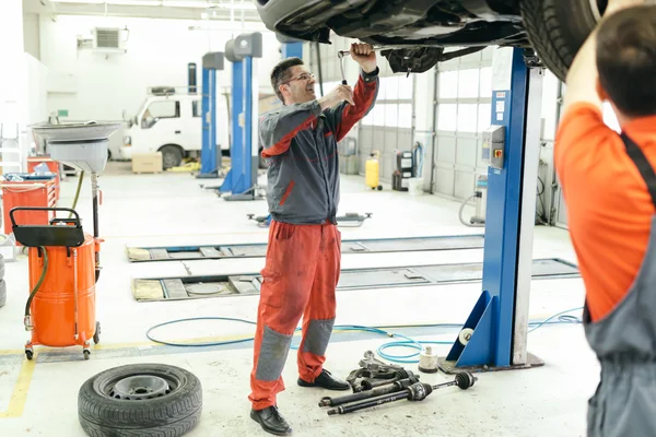 Car mechanics upkeeping car — Stock Photo, Image