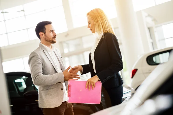 Kunde schaut sich Autos im Autohaus an — Stockfoto