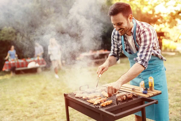 Amigos acampando y teniendo una barbacoa — Foto de Stock