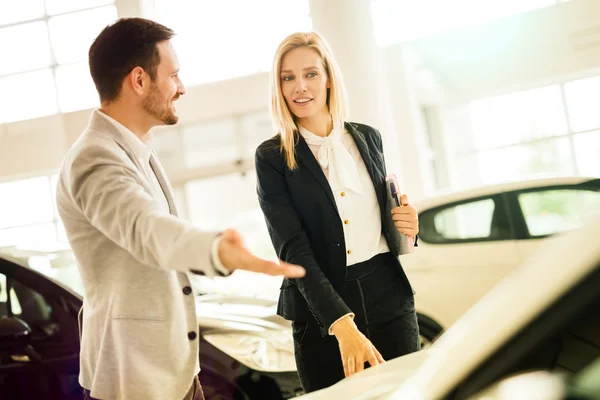 Vendedor mostrando vehículo al cliente potencial — Foto de Stock