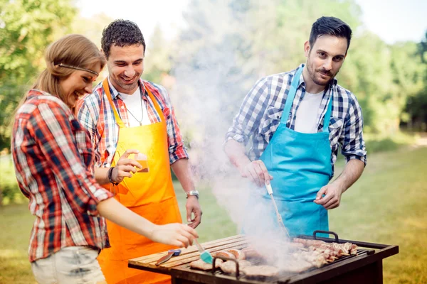 Νέους ανθρώπους που απολαμβάνουν barbecuing — Φωτογραφία Αρχείου