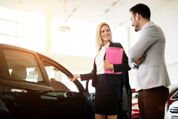 Cliente à procura de um carro na concessionária — Fotografia de Stock