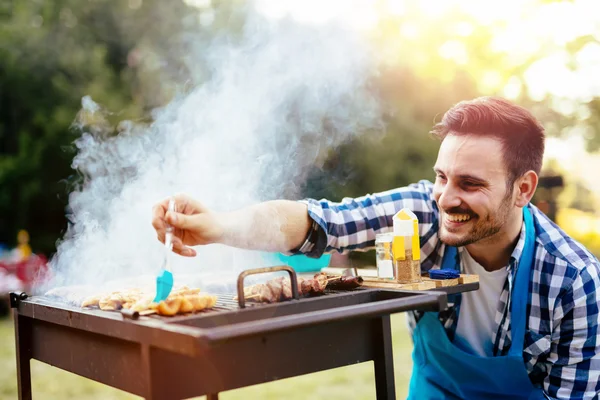 Kjekk mann som lager grillmat – stockfoto