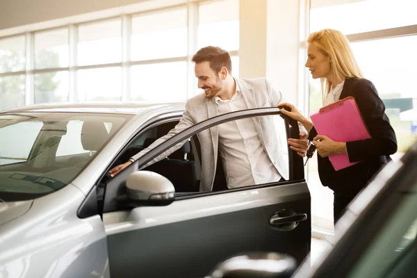 Salesperson showing vehicle to potential customer — Stock Photo, Image