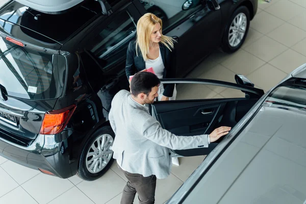 Salesperson working at car dealership — Stock Photo, Image