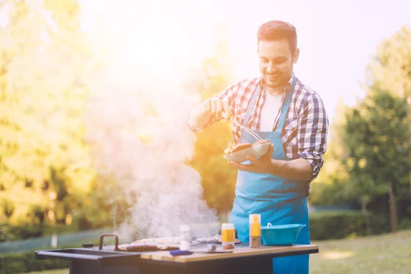 Bonito homem preparando churrasco — Fotografia de Stock