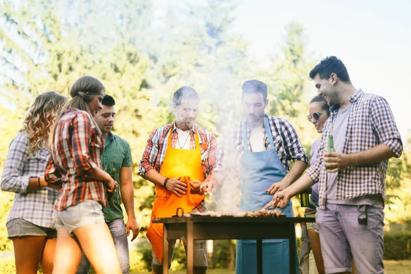 Unga människor njuta av grillning — Stockfoto