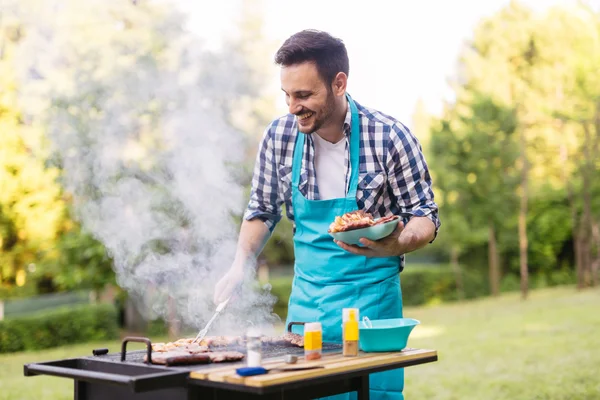 Kjekk mann som lager grillmat – stockfoto