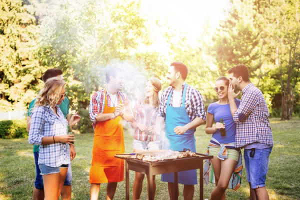 Unga människor njuta av grillning — Stockfoto
