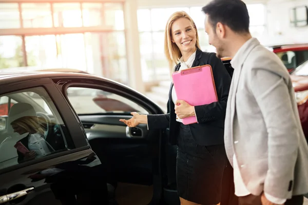 Salesperson showing vehicle to potential customer — Stock Photo, Image