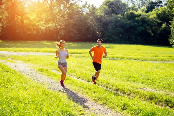 Athletic couple jogging in nature — Stock Photo, Image