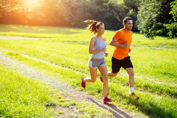 Athletic couple jogging in nature — Stock Photo, Image