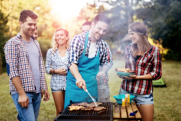 Amigos acampando y teniendo una barbacoa — Foto de Stock