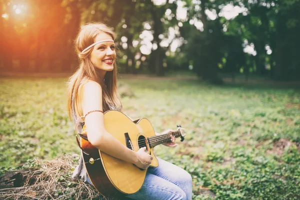 Schönes Hippie-Mädchen, das Gitarre spielt — Stockfoto