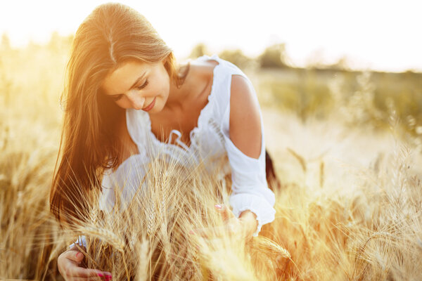 Beautiful woman hugging barley and wheat