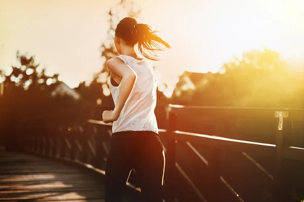 Beautiful jogger crossing bridge — Stock Photo, Image