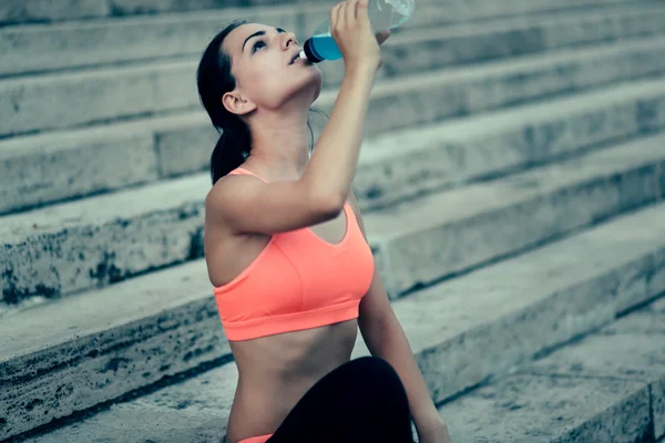 Thirsty sportswoman drinking water — Stock Photo, Image