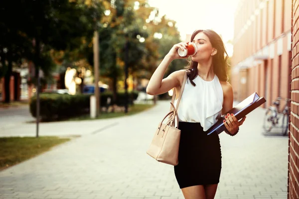 Businesswoman on the go drinking coffee