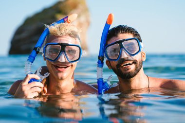 Mutlu arkadaşlar yaz tatilinin tadını çıkarıyorlar, seyahat ediyorlar. Scuba dalışı, şeffaf denizde yüzen şnorkelle yüzmek.