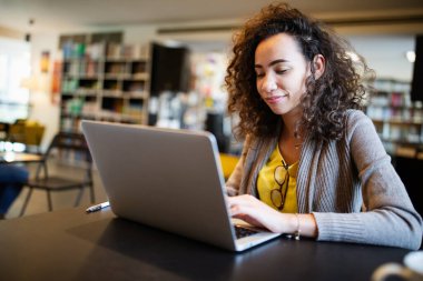 Dizüstü bilgisayarda çalışan mutlu genç bir kadının portresi