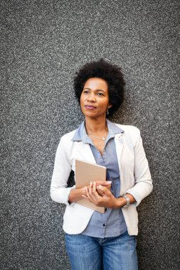 Dışarıda tablet bilgisayarı olan şehirli mutlu iş kadını