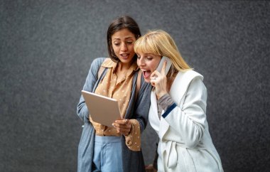 Dijital çağda yaşamak. Dışarıda elinde farklı dijital cihazlar tutan bir grup mutlu genç. teknoloji kavramı