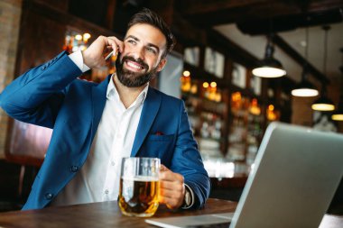 Restorandaki iş molasında dizüstü bilgisayar kullanan yakışıklı bir iş adamı.